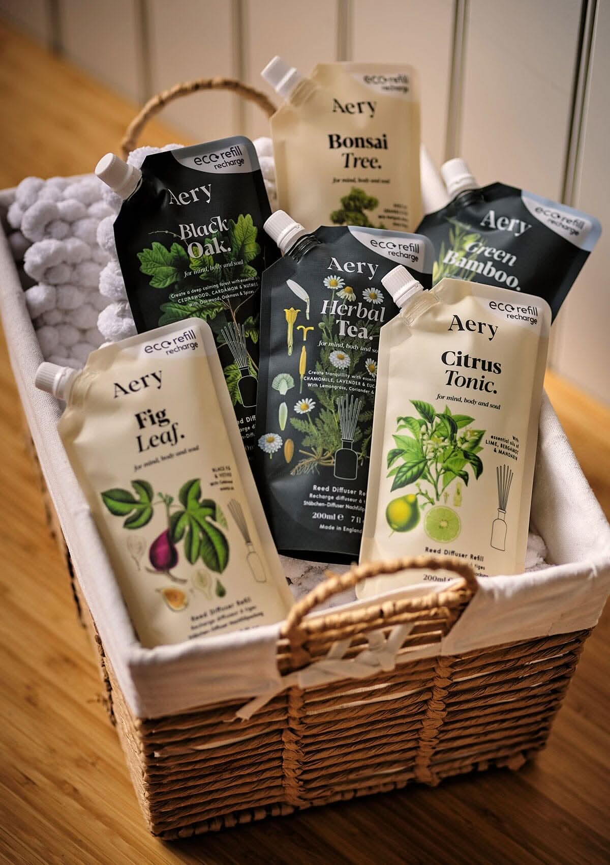 Collection of botanical reed diffuser refill pouches by aery displayed in wicker basket