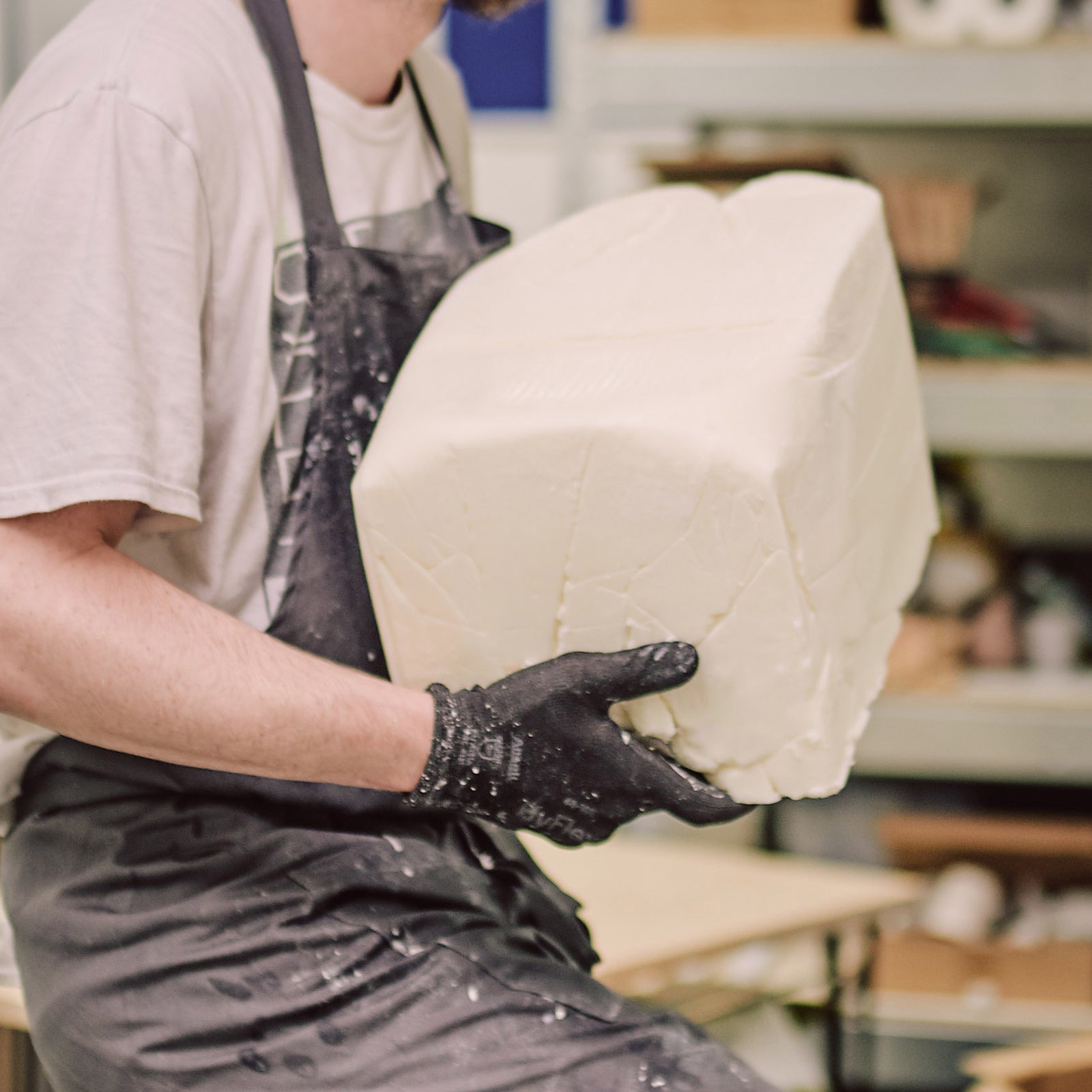 Person carrying large block of plant based wax ready for candle making