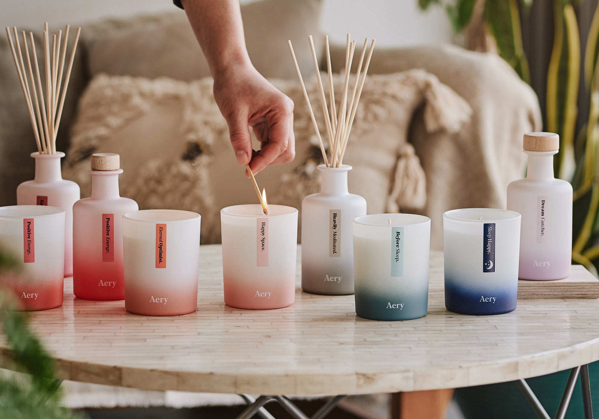 collection of aery living aromatherapy candles and diffusers decoratively displayed on a coffee table