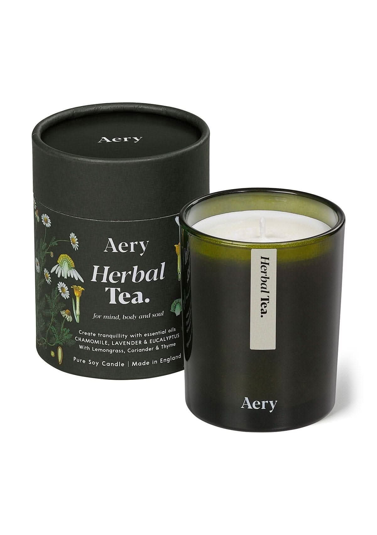 Green herbal Tea glass scented candle displayed next to product packaging on white bacground