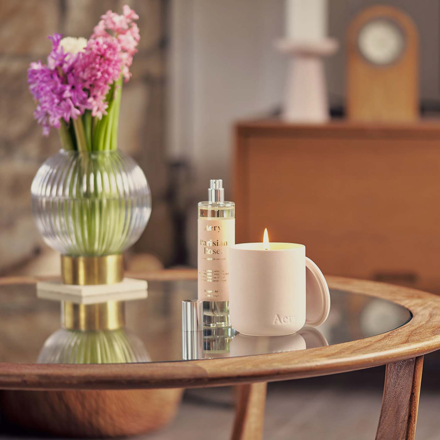 Fernweh Parisian Rose candle and room mist by aery next to pink flowers