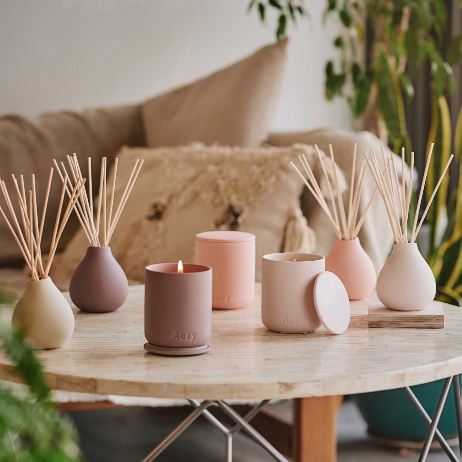 A collection of fernweh aery living candles in pink neutral tones decoratively displayed on coffee table