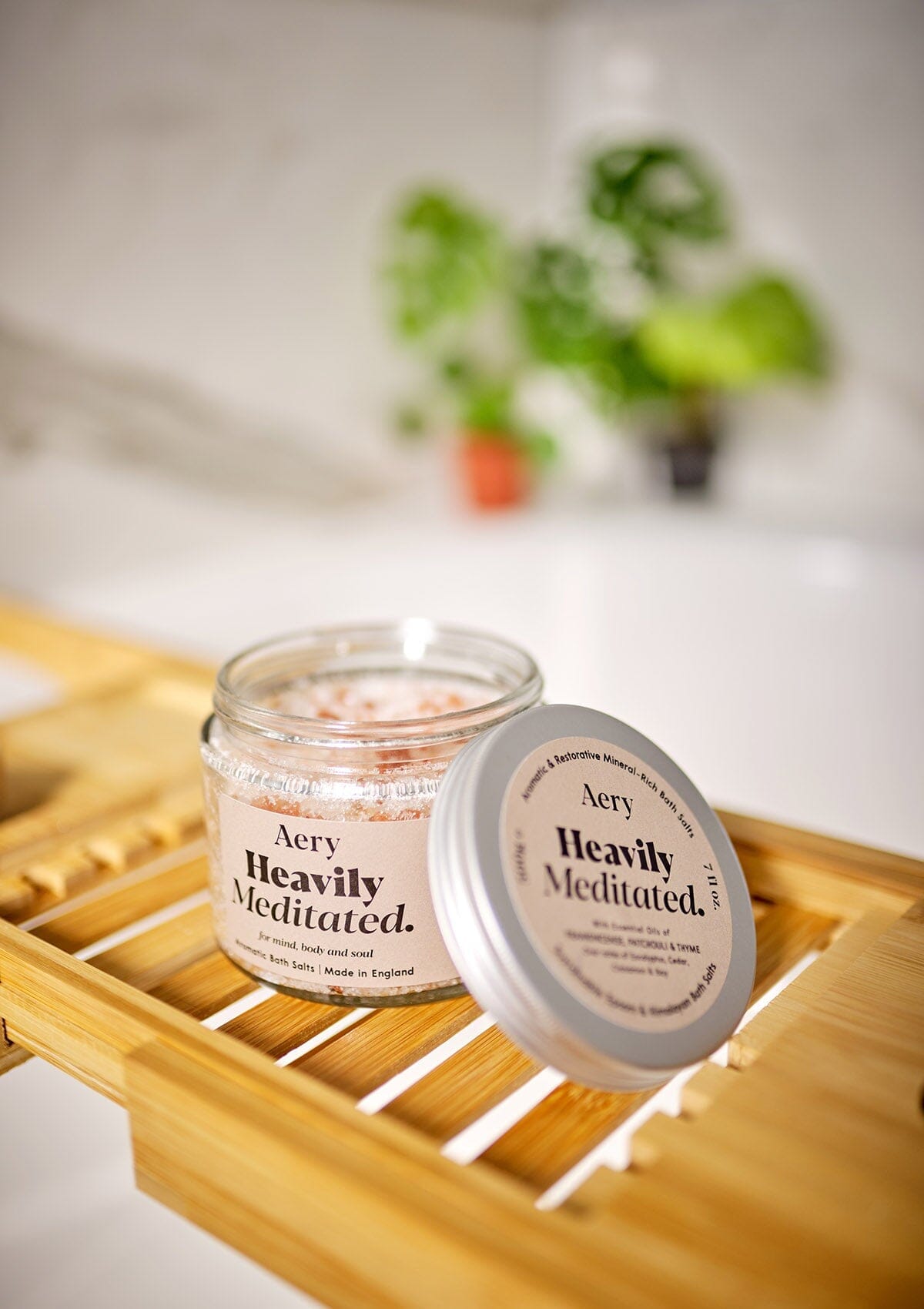 Aery Living Heavily Meditated bath salts with lid off on bath tray in bathroom setting
