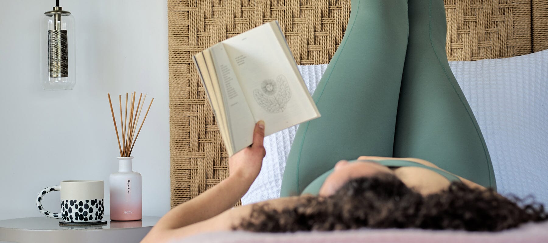 person laying on bed reading a book