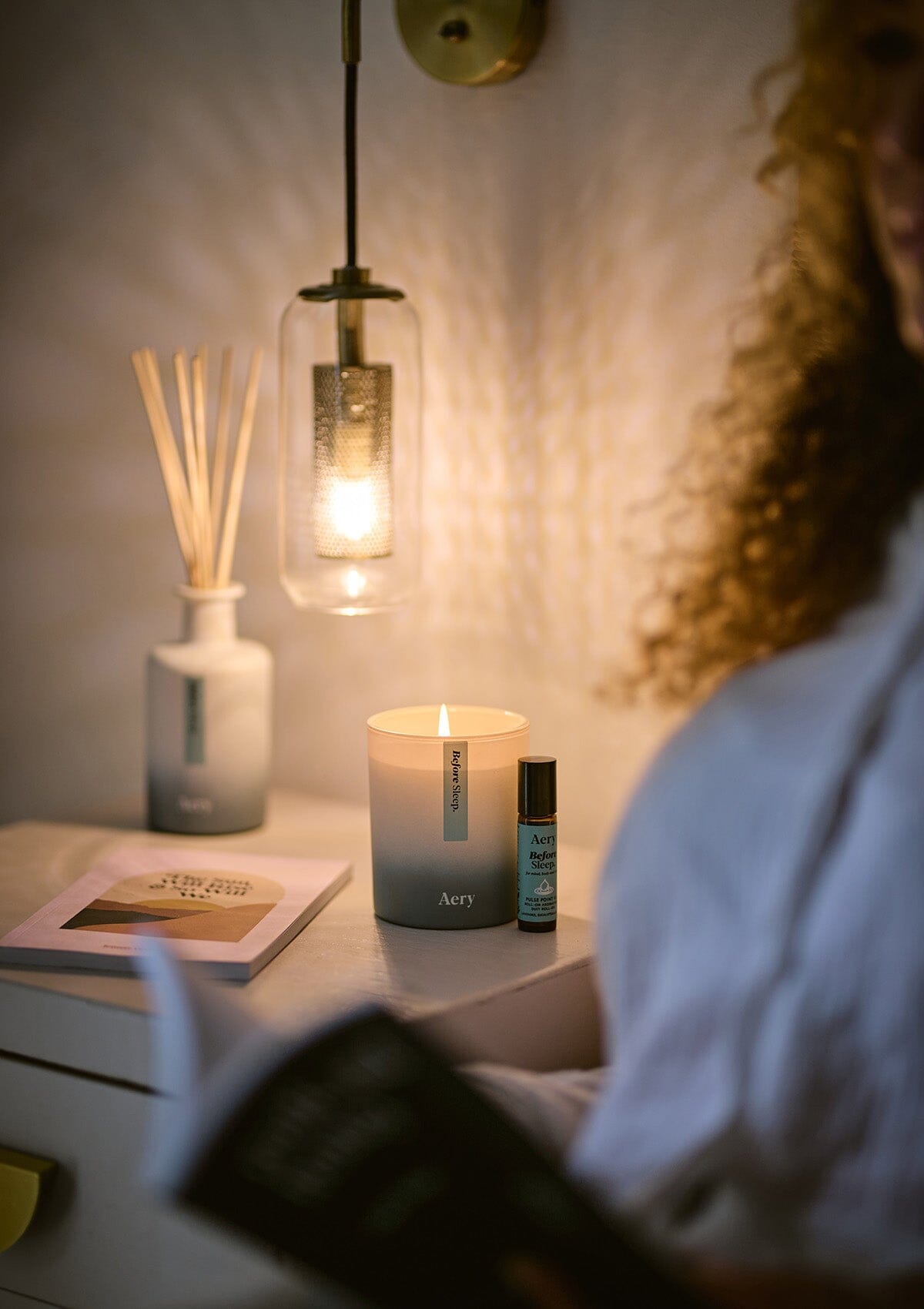 Blue Before Sleep pulse point oil displayed next to Before Sleep candle and diffuser by Aery on bedside table 