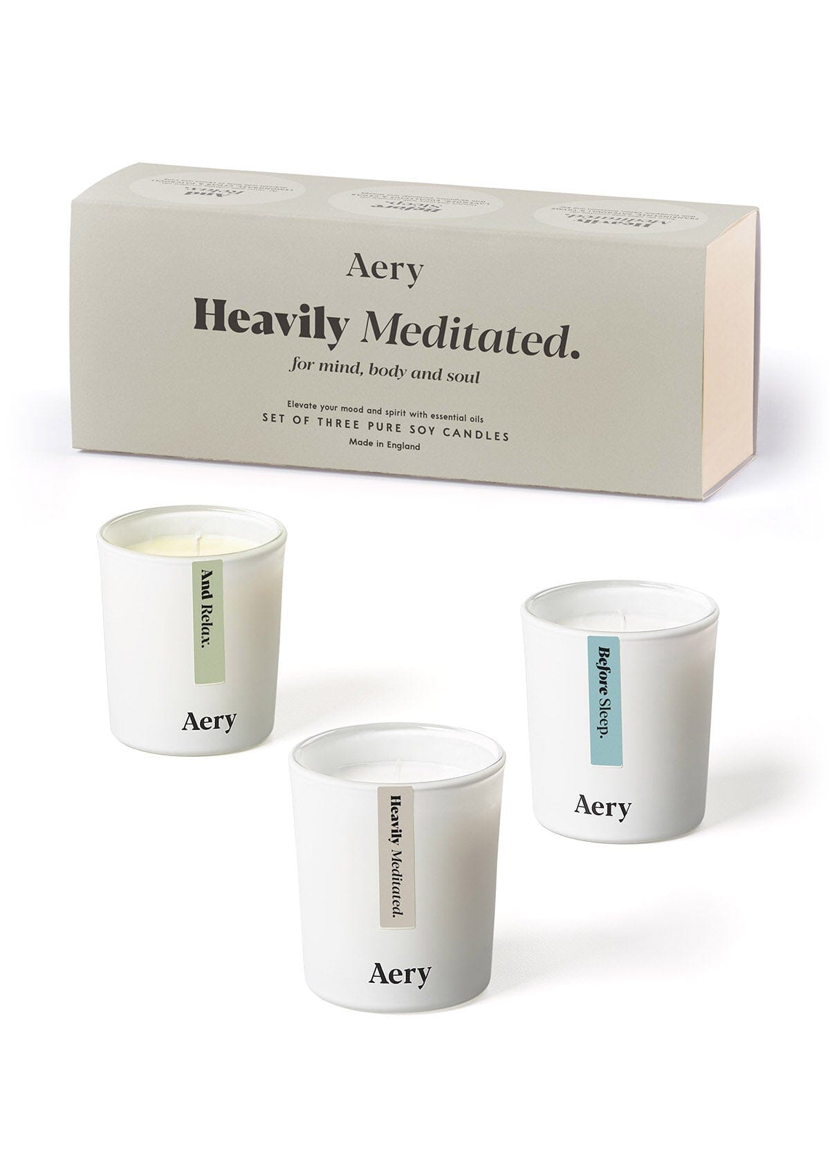 Beige Heavily Meditated candle set of three by Aery displayed next to product packaging 