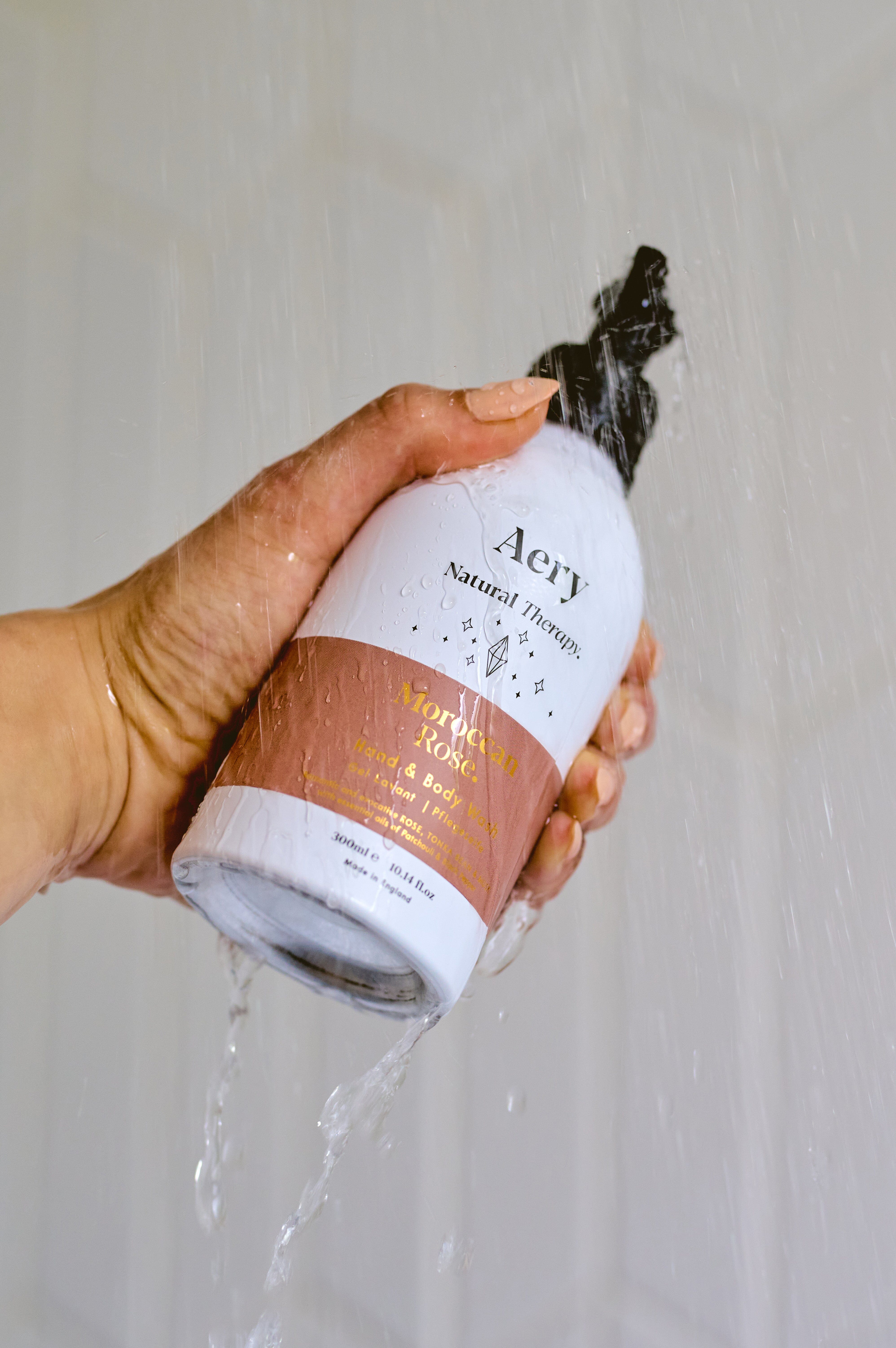 Aubergine Moroccan Rose hand wash by Aery displayed in hand in shower 