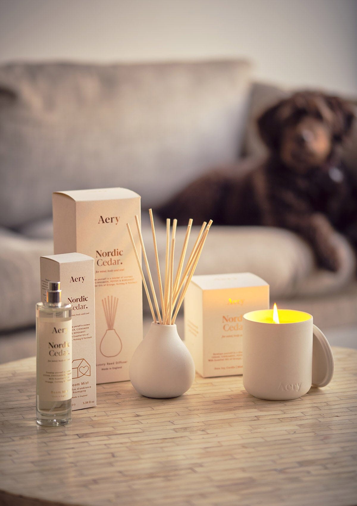 White Nordic Cedar candle, diffuser and room spray by Aery displayed on cream circle table 