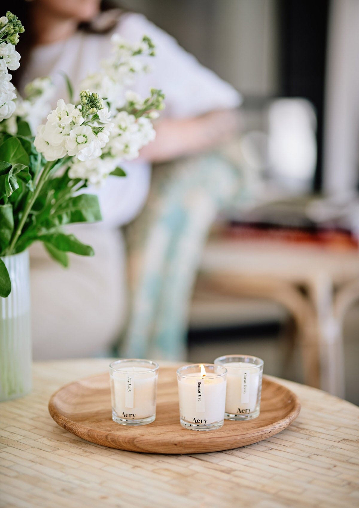 Cream botanical set of three candles Displayed on wooden tray with vase of white flowers