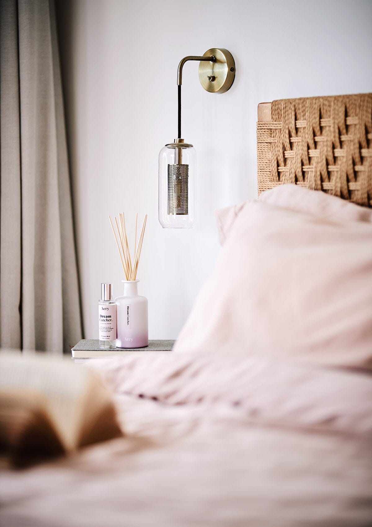 Lilac Dream Catch diffuser by Aery displayed next to Dream Catcher pillow mist placed in bedroom on bedside table 