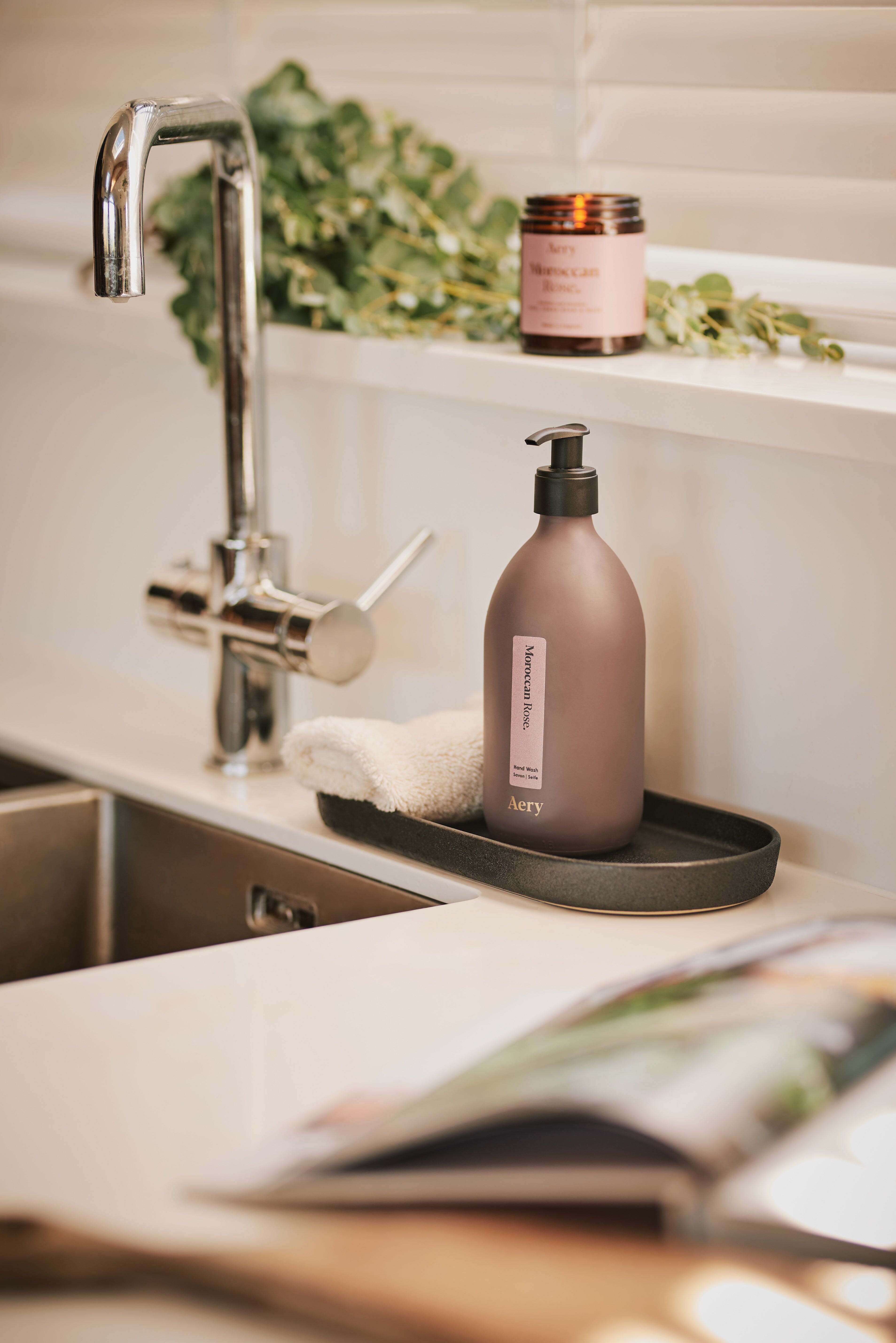 Aubergine Moroccan Rose hand wash by Aery displayed next to Moroccan rose jar candle place by the kitchen sink 
