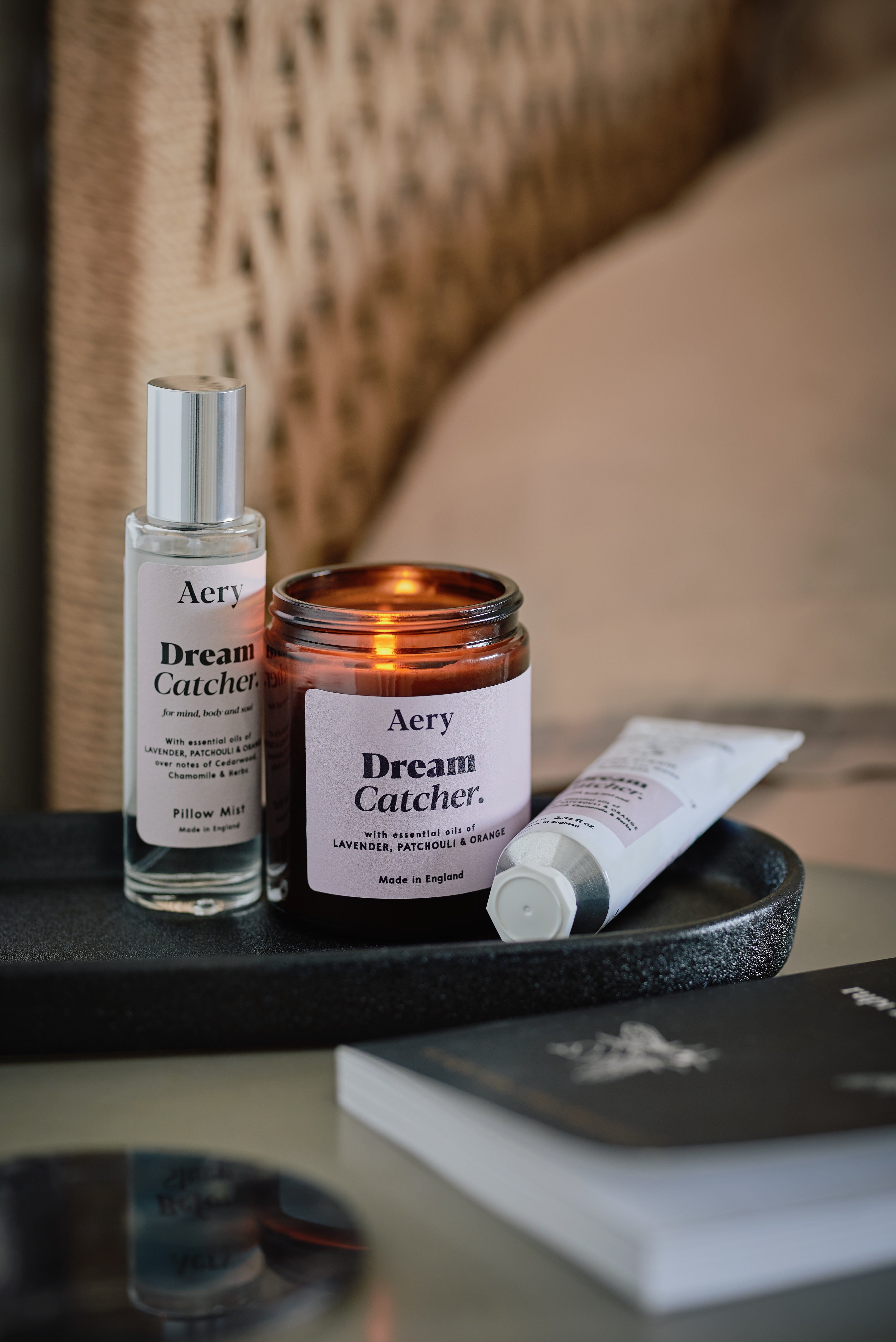 Lilac Dream Catcher jar candle by Aery displayed next to Dream Catcher room mist and hand cream on black tray place on bedside table 