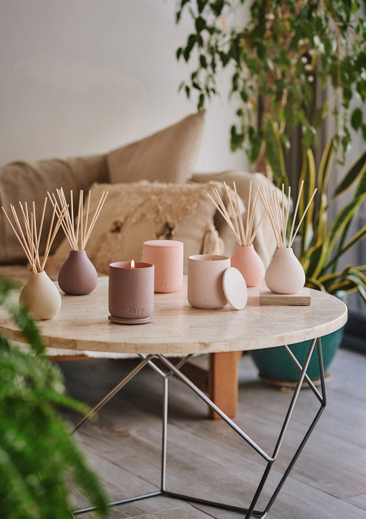 Collection of fernweh candle and diffusers by aery placed on cream circle table 