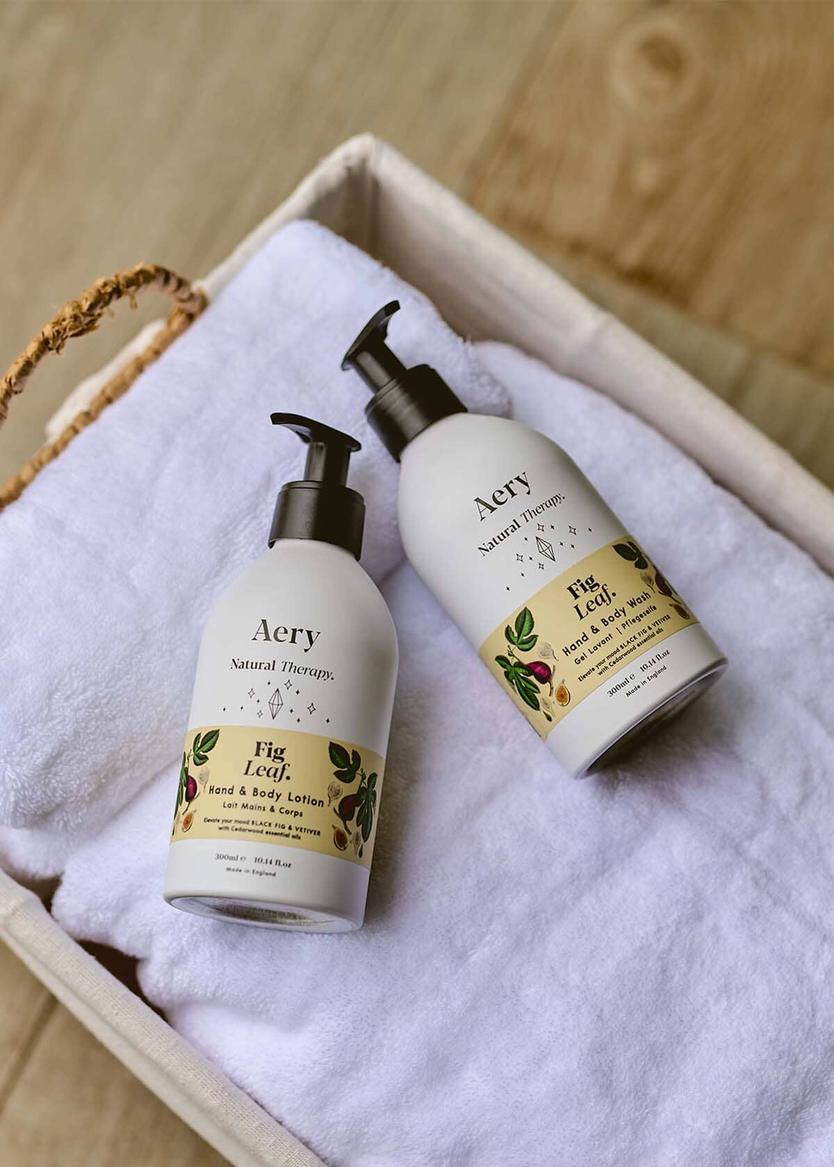 Cream Fig Leaf hand and body wash and lotion duo displayed on white towel in basket 