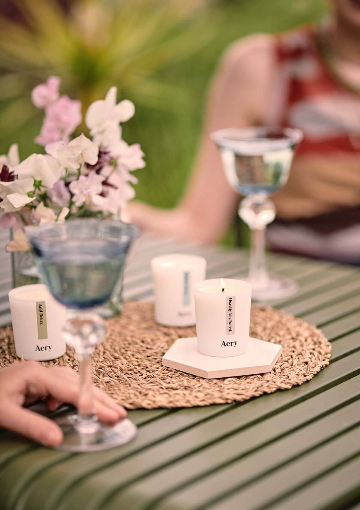 Beige Heavily Meditated gift set of three candles by aery displayed on outside garden table 