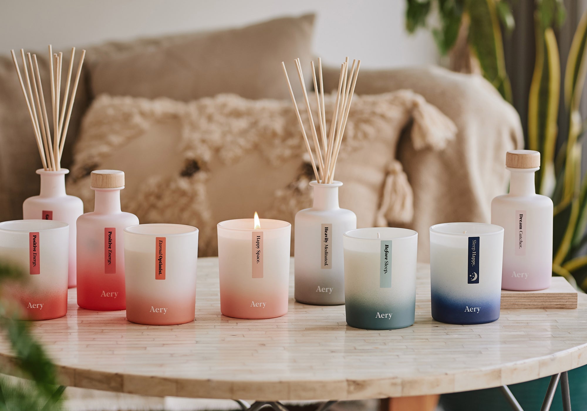 collection of aery living aromatherapy candles and diffusers decoratively displayed on a coffee table