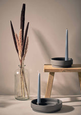 pair of ceramic candle holders in a neutral setting with contrast blue coloured candles and dried grasses in decorative vase