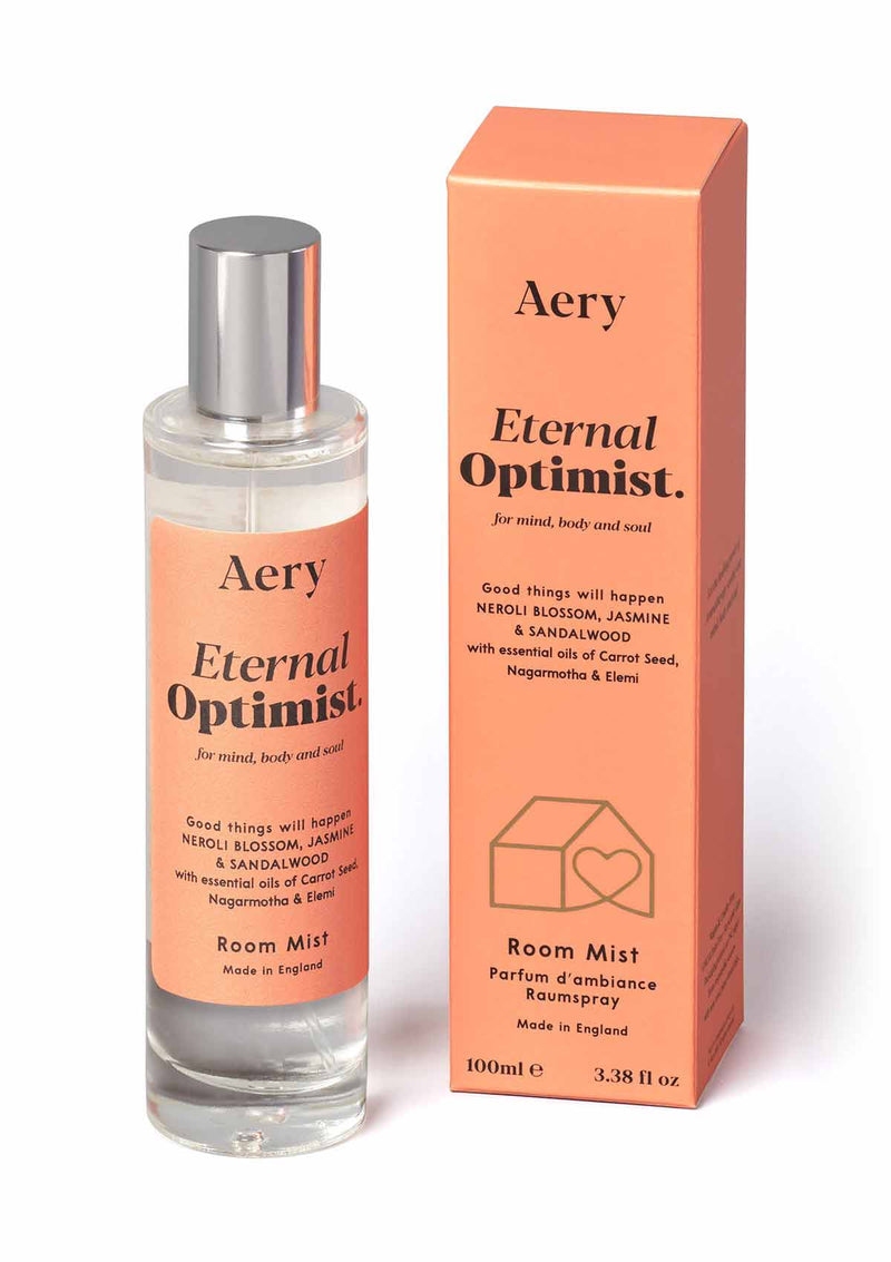 aery living eternal optimist room spray bottle next to orange product packaging