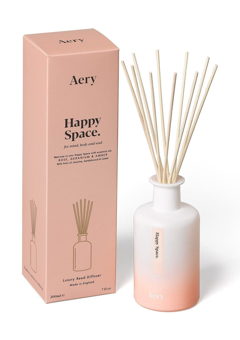 aery living happy space reed diffuser next to pink product packaging