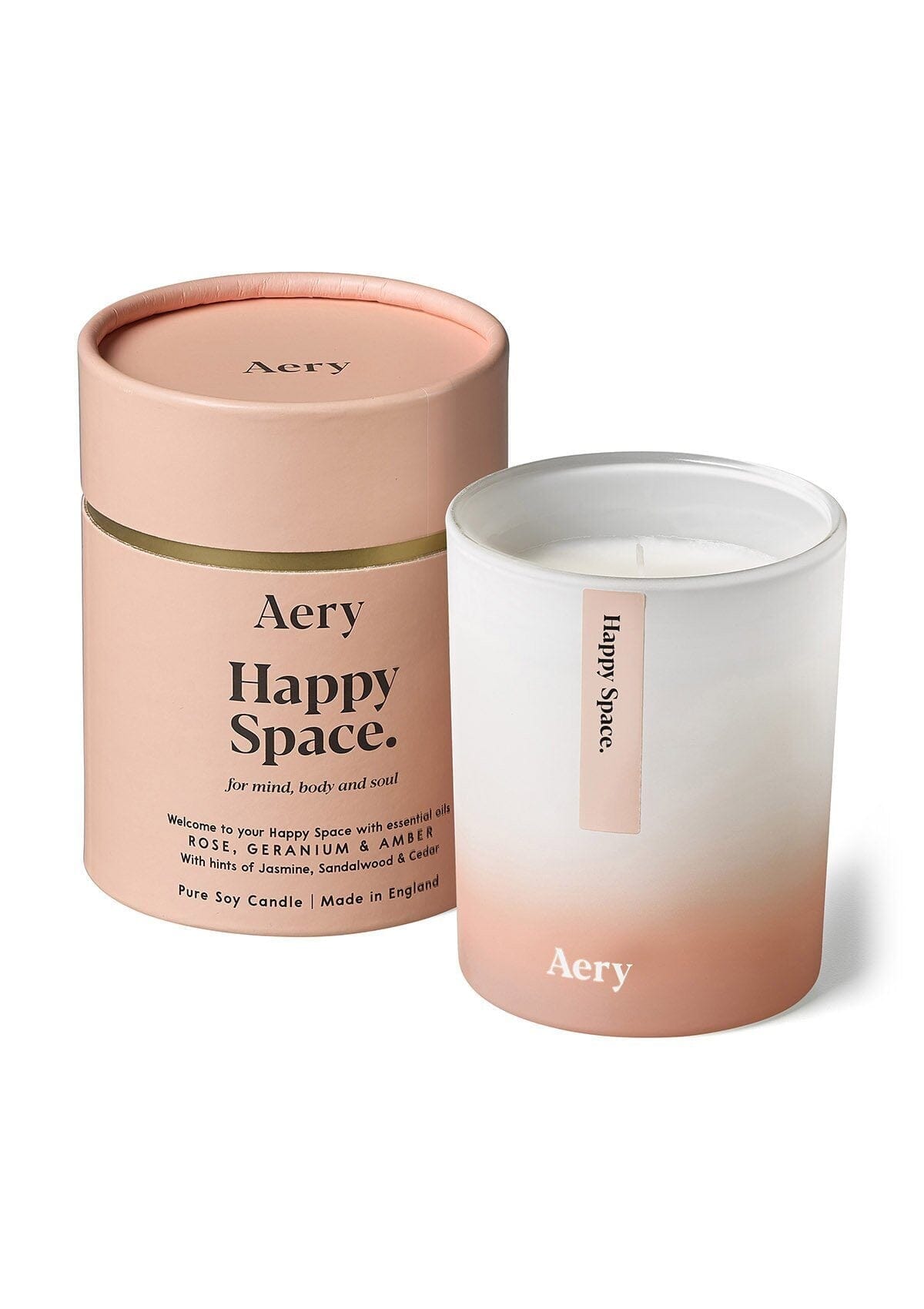 aery living happy space scented candle next to pink product packaging