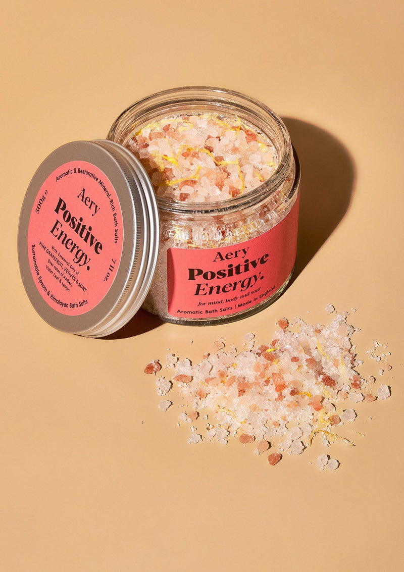 aery living positive energy bath salts in glass jar with salts decoratively sprinkled in front